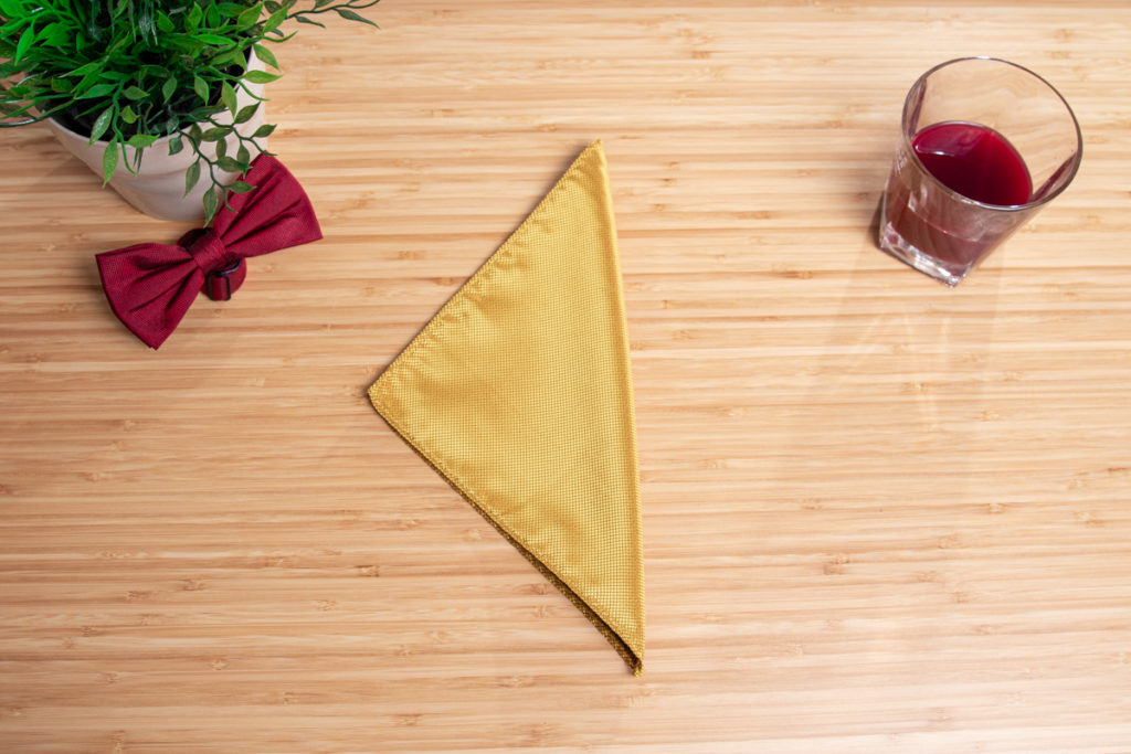 A yellow pocket square is folded to a three point fold.